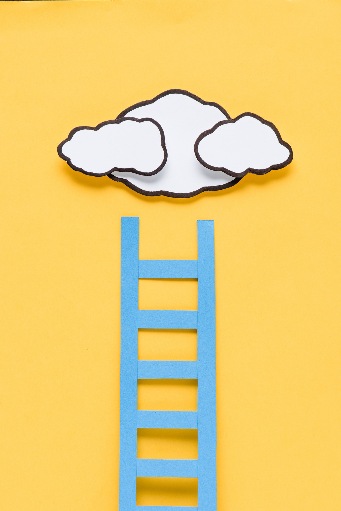 top view of paper ladder with clouds on yellow background, setting goals concept